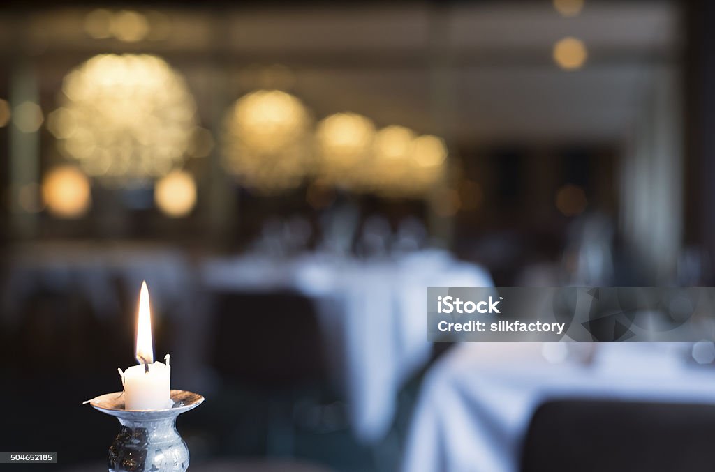 Candle light and defocused elegant dining room background with chandeliers Candle light and defocused dining room background. Defocused Stock Photo