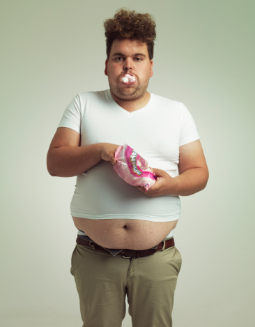 Shot of an overweight man with marshmallows shoved in his mouth