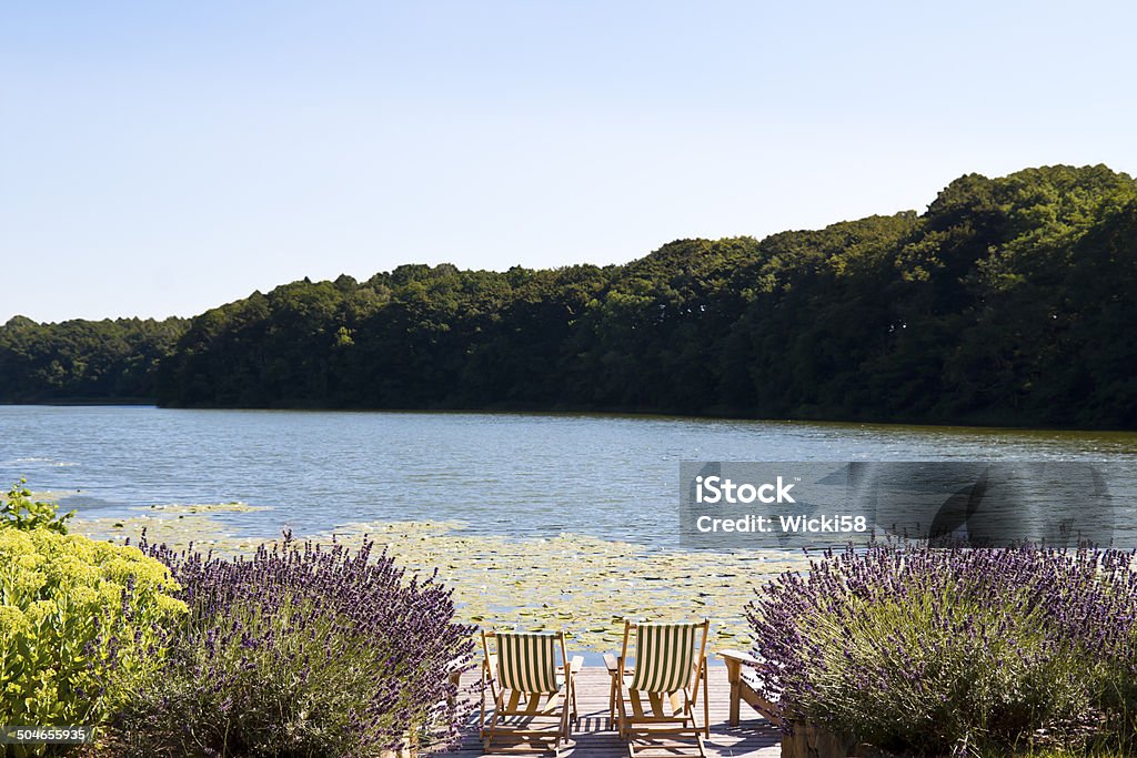 라운지 의자가 있는 데크 있는 호수 - 로열티 프리 0명 스톡 사진
