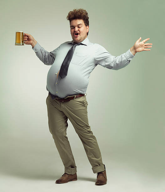 I'm a party animal! Shot of an overweight man celebrating while holding a pint of beer pot belly stock pictures, royalty-free photos & images