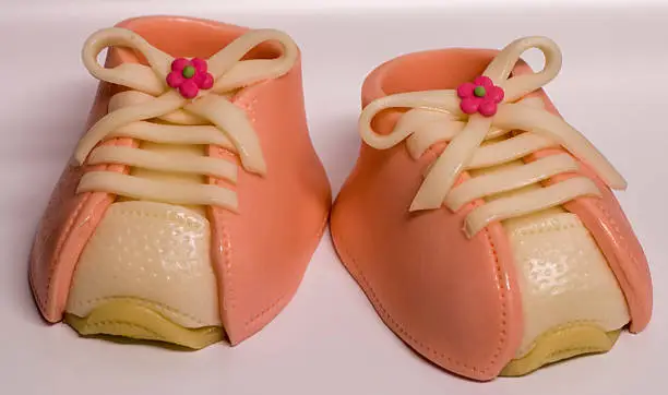 A pair of babyshoes made of marzipan. Pink color for a girl