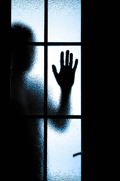 istock Scared boy behind glass door 504685567