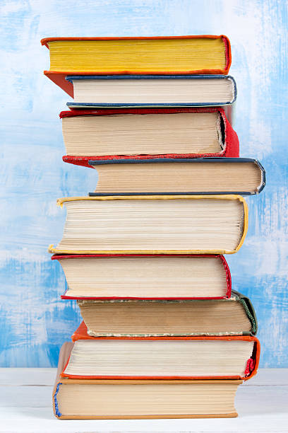 istock Stack of colorful hardback books, open book on blue background 504694184