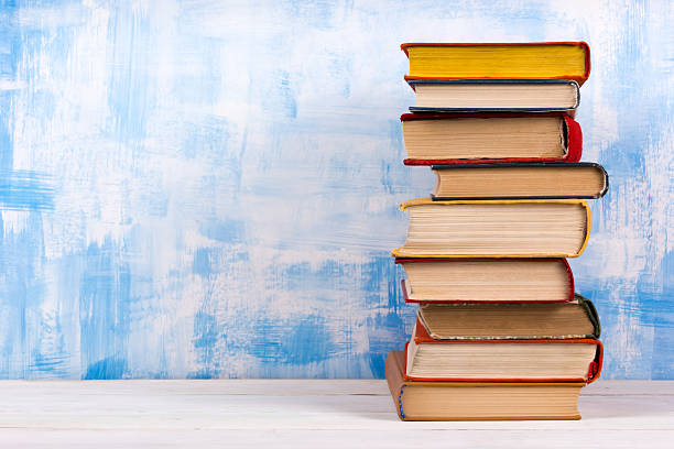 istock Stack of colorful hardback books, open book on blue background 504694238