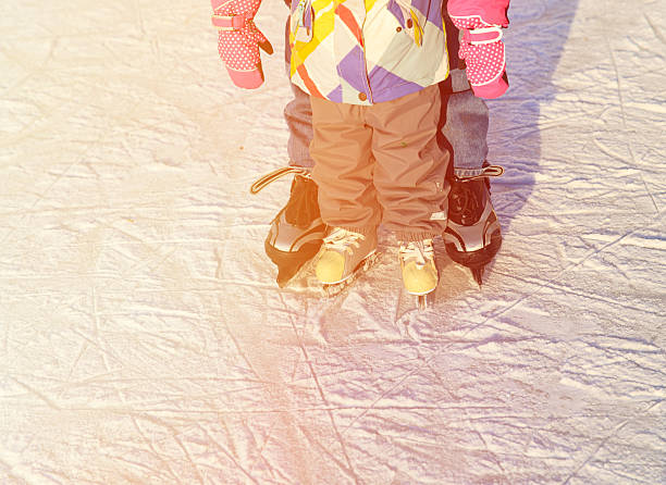 父と娘の小さな足を学ぶカルミア冬 - ice hockey action ice skating ice skate ストックフォトと画像