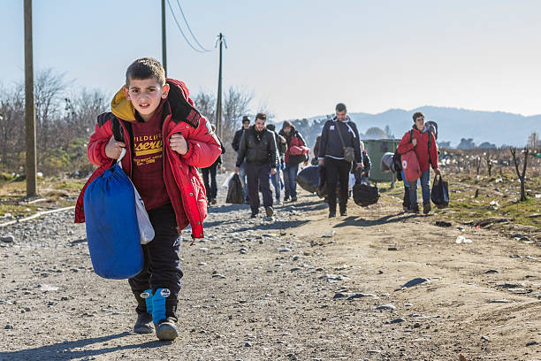 los refugiados que cruzan la frontera entre grecia y macedonia en gevgelija - iraq conflict fotografías e imágenes de stock