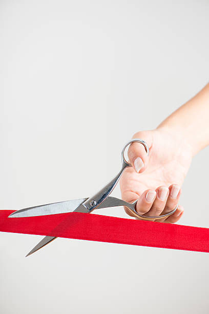 istock Woman using scissors to cut opening ribbon 504698216