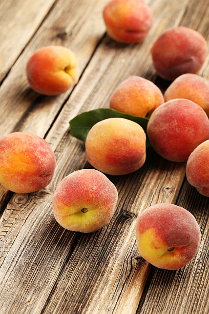 istock Ripe peaches fruit on a brown wooden background 504699568