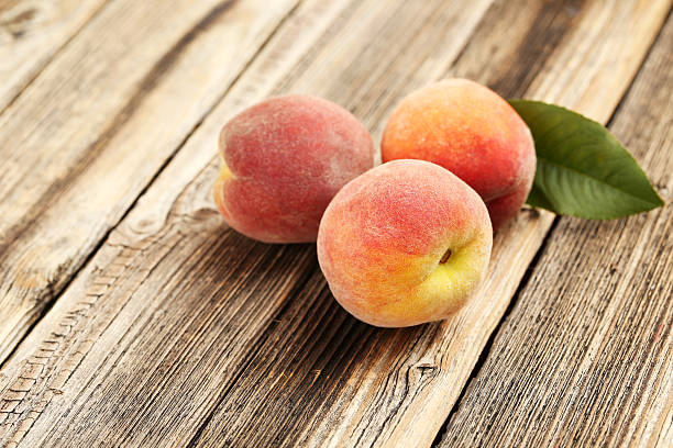istock Ripe peaches fruit on a brown wooden background 504701058