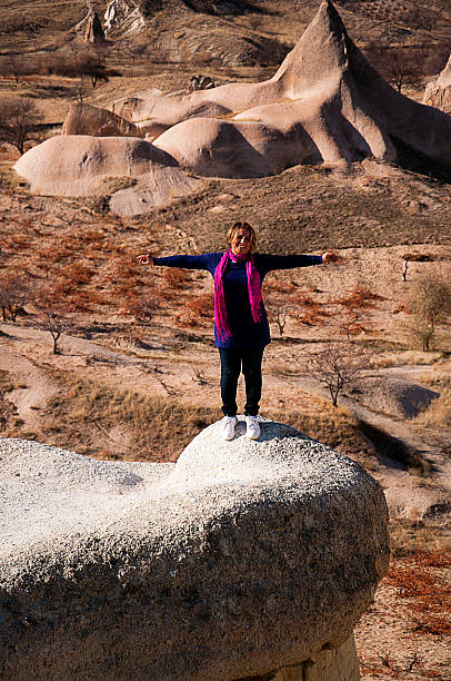 istock blonde woman with open arms on the interesting rocks 504701830