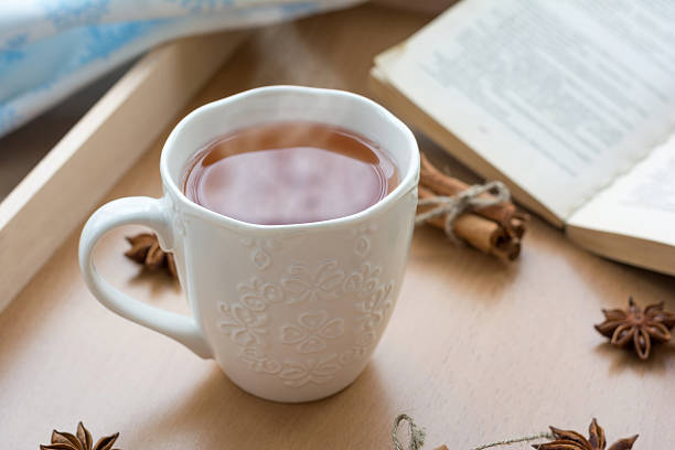 istock Hot morning tea with open book on background 504702516