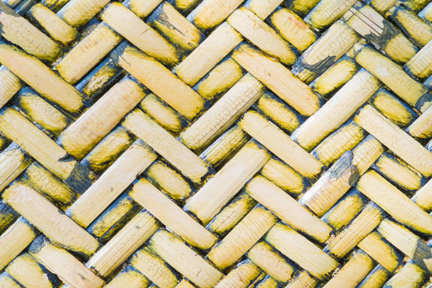 Pattern of Thai style bamboo handcraft background Detail close up view of a uniform golden woven basket using natural branch materials.Pattern of Thai style bamboo handcraft texture background interlace format stock pictures, royalty-free photos & images