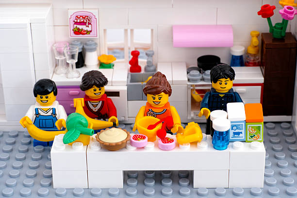 Tambov, Russian Federation - August 29, 2015: Lego family in domestic kitchen. Woman is cooking dessert. Custom set. Studio shot.