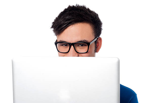 istock Mischievous boy hiding his face with laptop 504706657
