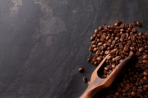 Coffee beans on stone table. Top view with copy space