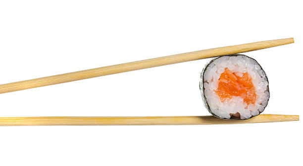 istock Salmon sushi roll in chopsticks isolated on white background 504707329