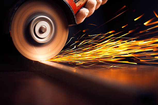 istock Worker cutting metal with grinder. Sparks while grinding iron 504707689