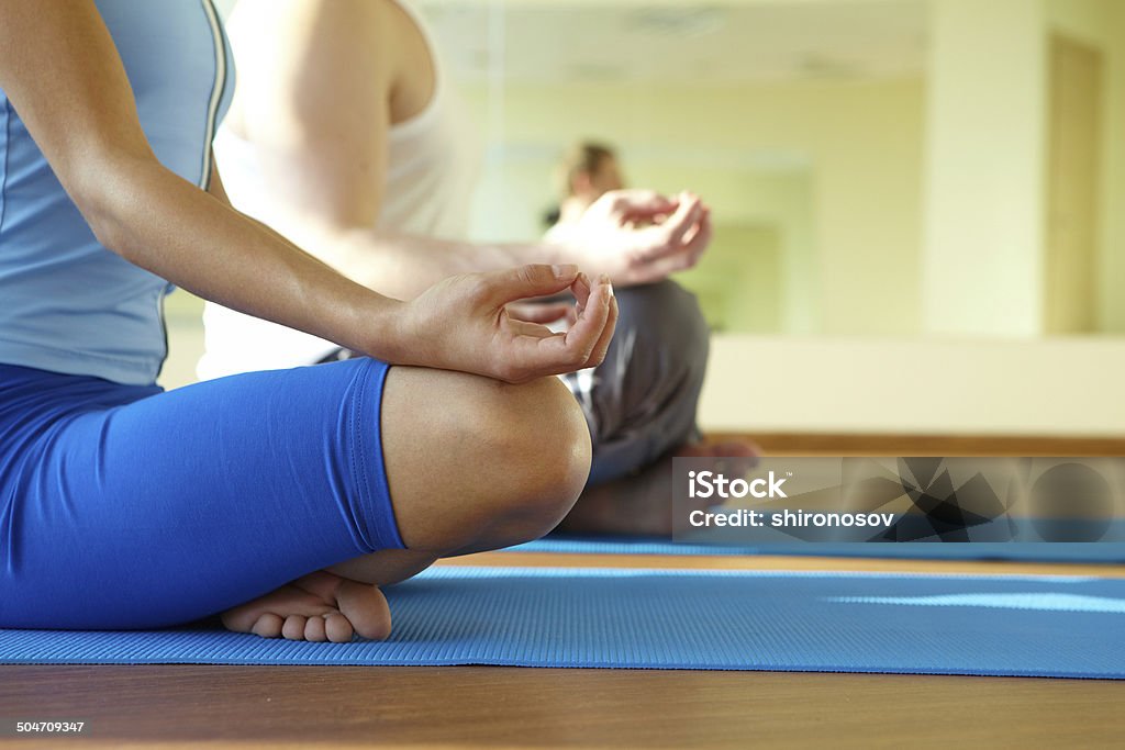Spiritual harmony Close-up of feminine and masculine arms and crossed legs during meditation Close-up Stock Photo