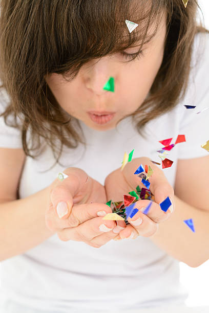 istock Young woman blows confetti with palms 504711436