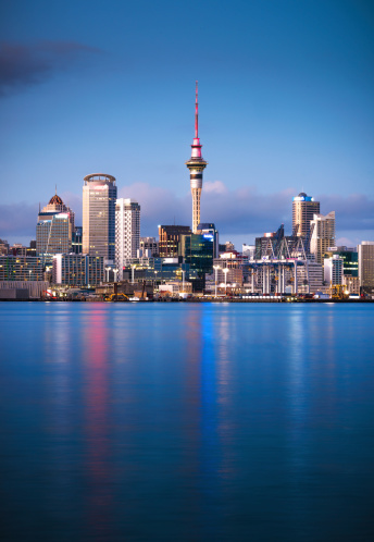 Auckland's CBD seen from across the water at dawn, with the Sky Tower in the centre of the image.