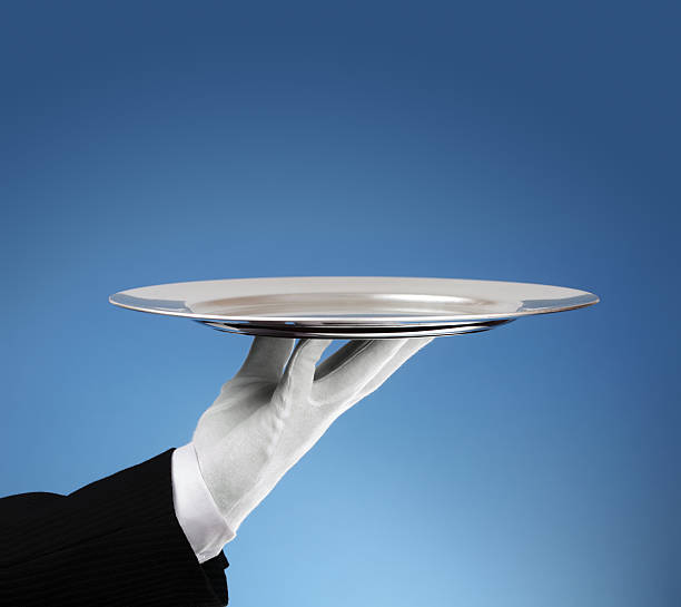 Waiter with empty silver tray Waiter holding an empty silver platter ready for product placement or message formal glove stock pictures, royalty-free photos & images