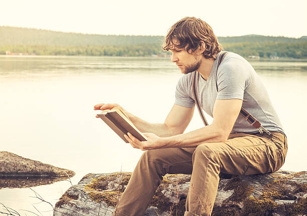 istock Young Man reading book outdoor Summer vacations Lifestyle 504737267