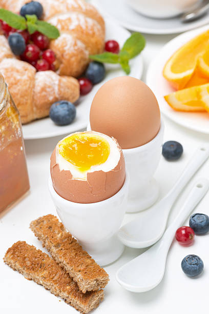 breakfast with eggs, toasts, croissants, fresh berries