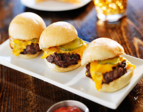 three mini burger sliders in a row shot close up