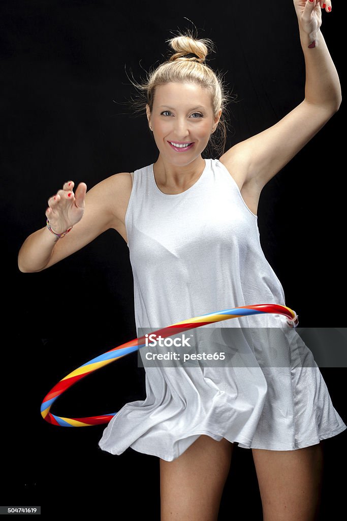 Young woman playing with a hula hoop. Color image Young woman playing with a colorful hula hoop. Color image. Adult Stock Photo