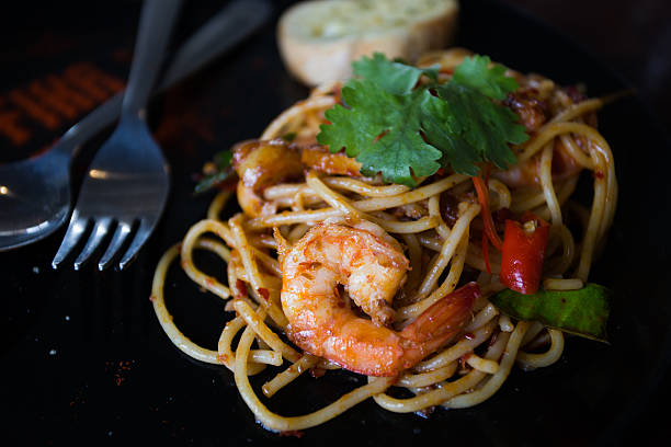 istock Hot spicy spaghetti seafood with bread . 504742342