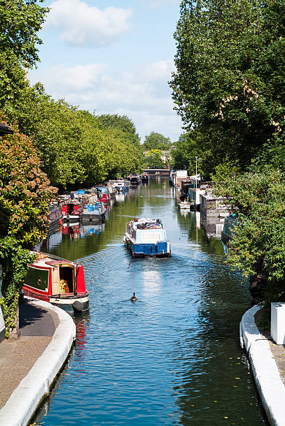 Little Venice a boat travelling along the Little Venice canal in London on a sunny day little venice london stock pictures, royalty-free photos & images