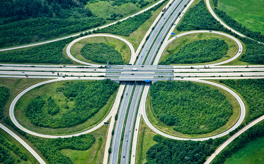 An elevated view of a clover leaf shaped highway interchange. This is the 