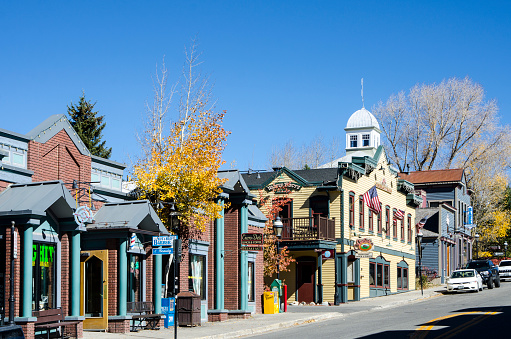 Breckenridge, Colorado, USA - October 12, 2015: Main Street runs through the town of Breckenridge, Colorado which was created in November 1859 by General George E. Spencer, the historic Town of Breckenridge is the most populous municipality of Summit County, Colorado, United States. The town is located at the base of the Tenmile Range. Summer in Breckenridge attracts outdoor enthusiasts with hiking trails, wildflowers, fly-fishing in the Blue River, mountain biking, nearby Lake Dillon for boating, white water rafting, alpine slides, and several shops up and down Main Street. In December 1961, skiing was introduced to Breckenridge when several trails were cut on the lower part of Peak 8, connected to town by Ski Hill Road. In the 50-plus years since, Breckenridge Ski Resort gradually expanded onto Peak 9 and Peak 10 on the south end of town, and Peak 7 and Peak 6 to the northwest of town.