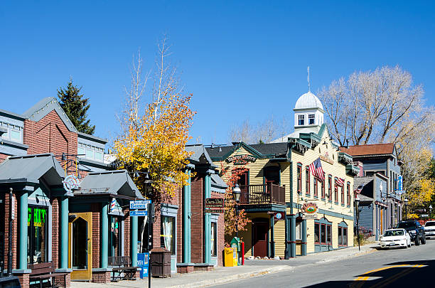 Breckenridge, Colorado Breckenridge, Colorado, USA - October 12, 2015: Main Street runs through the town of Breckenridge, Colorado which was created in November 1859 by General George E. Spencer, the historic Town of Breckenridge is the most populous municipality of Summit County, Colorado, United States. The town is located at the base of the Tenmile Range. Summer in Breckenridge attracts outdoor enthusiasts with hiking trails, wildflowers, fly-fishing in the Blue River, mountain biking, nearby Lake Dillon for boating, white water rafting, alpine slides, and several shops up and down Main Street. In December 1961, skiing was introduced to Breckenridge when several trails were cut on the lower part of Peak 8, connected to town by Ski Hill Road. In the 50-plus years since, Breckenridge Ski Resort gradually expanded onto Peak 9 and Peak 10 on the south end of town, and Peak 7 and Peak 6 to the northwest of town. aspen colorado photos stock pictures, royalty-free photos & images