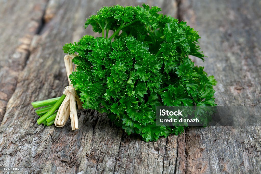 tied fresh parsley tied fresh parsley on wooden surface Arrangement Stock Photo