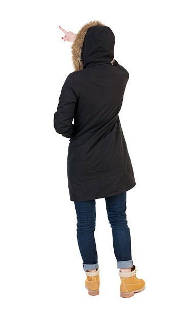 vista posterior de joven mujer apuntando en parka. - looking at view watching pointing showing fotografías e imágenes de stock