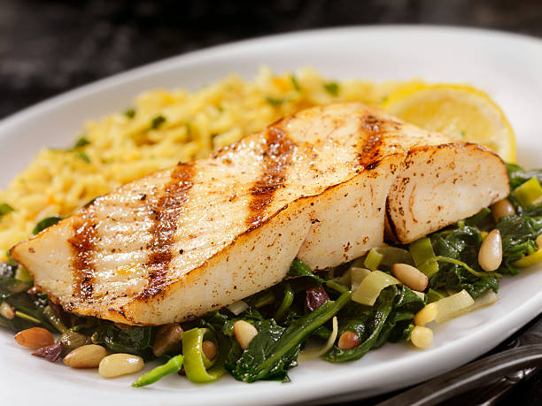 pesce grigliato con spinaci, porri e riso - healthy eating close up lemon nut foto e immagini stock