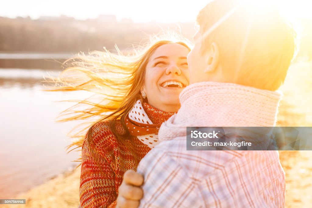 Couple in love laughing Couple in love laughing and having fun at sunset with sun flares Adult Stock Photo