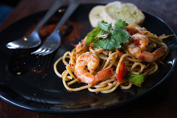istock Hot spicy spaghetti seafood with bread . 504757966