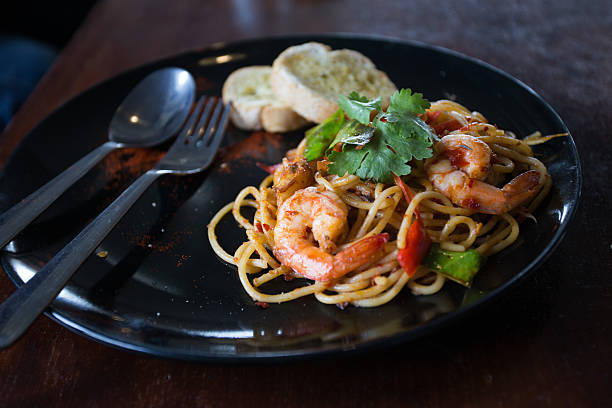 istock Hot spicy spaghetti seafood with bread . 504758058
