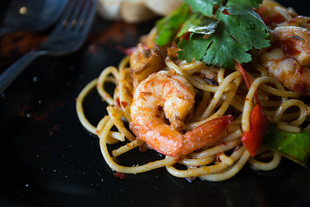 istock Hot spicy spaghetti seafood with bread . 504758188