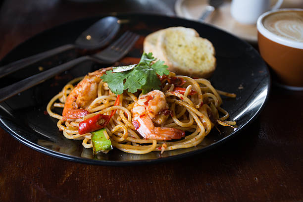 istock Hot spicy spaghetti seafood with bread . 504758394