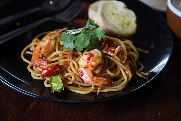 istock Hot spicy spaghetti seafood with bread . 504758544
