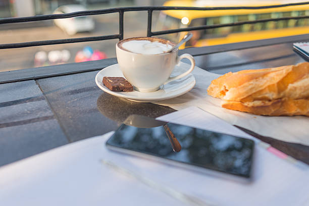 passo fuori pane, tazza di cappuccino e smartphone sulla scrivania - coffee muffin pastry blueberry muffin foto e immagini stock