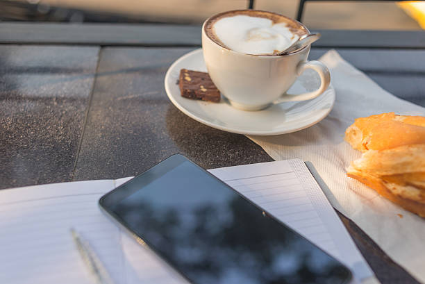 pezzo di assideramento out pane, tazza di caffè con smartphone - coffee muffin pastry blueberry muffin foto e immagini stock