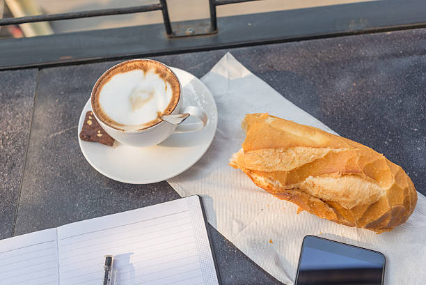 Morning sunlight shinning on desk with notebook, coffee, bread Morning sunlight shinning on desk with notebook, coffee, bread sandwich new hampshire stock pictures, royalty-free photos & images