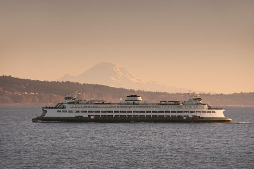 A ferry from Edmonds Washington makes the crossing to Kingston on the Olympic Peninsula in the Puget Sound area of western Washington state. Mt. Rainier is in the background