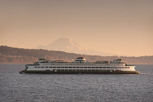 Ferryboat and Mt. Rainier A ferry from Edmonds Washington makes the crossing to Kingston on the Olympic Peninsula in the Puget Sound area of western Washington state. Mt. Rainier is in the background edmonds stock pictures, royalty-free photos & images