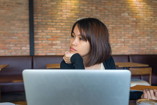 女性彼女の濃度ルーズにノートパソコンや見回す - document file emotional stress paperwork ストックフォトと画像