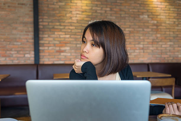 rapariga solta a sua concentração no computador portátil e olhar em redor - document file emotional stress paperwork imagens e fotografias de stock